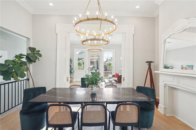 dining room featuring an inviting chandelier, ornamental molding, and light hardwood / wood-style flooring