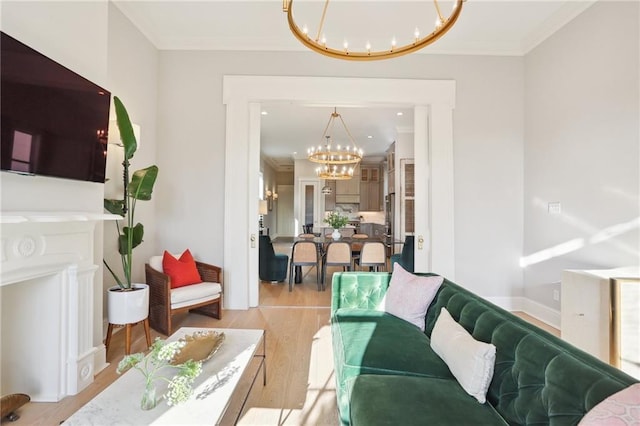 living room featuring an inviting chandelier, ornamental molding, and light hardwood / wood-style flooring