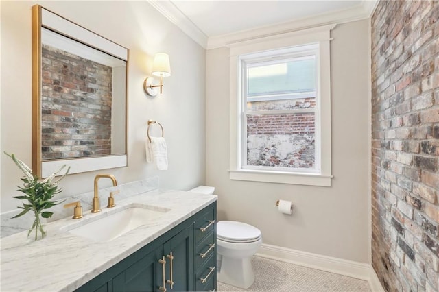 bathroom featuring tile patterned floors, toilet, crown molding, vanity, and brick wall