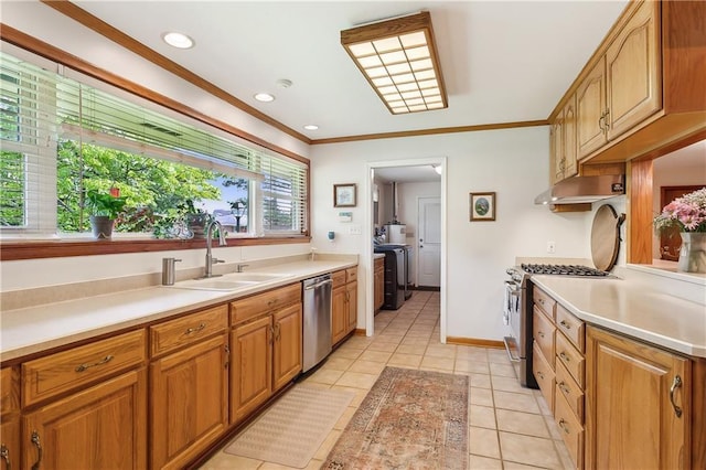 kitchen featuring independent washer and dryer, sink, wall chimney range hood, stainless steel appliances, and light tile patterned flooring