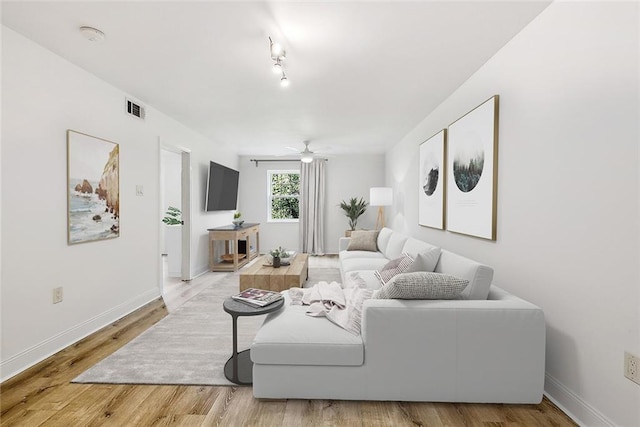 living room with light hardwood / wood-style floors and ceiling fan