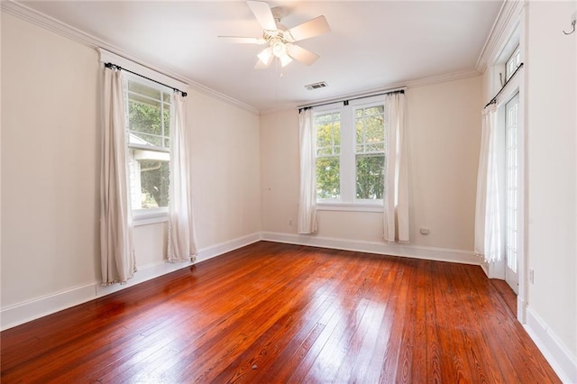 spare room featuring a healthy amount of sunlight, dark wood-type flooring, and ornamental molding