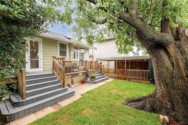 back of property featuring a deck and a lawn