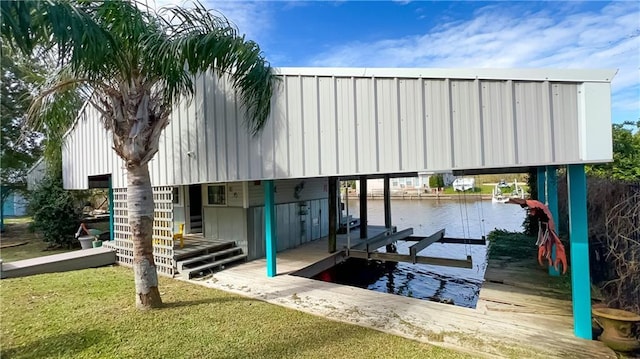 view of dock featuring a water view and a yard