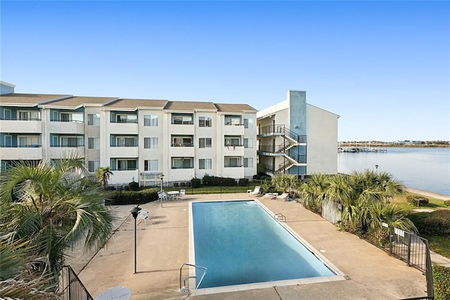 view of swimming pool with a patio area and a water view