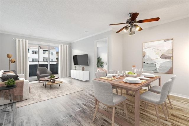 dining space featuring hardwood / wood-style flooring, ornamental molding, and ceiling fan