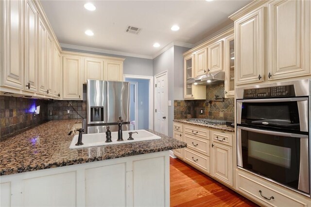 700 Dewey Ave, Slidell, LA 70458 - kitchen featuring stainless steel appliances, cream cabinets, crown molding, backsplash, and glass insert cabinets