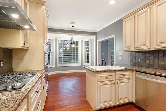 kitchen featuring kitchen peninsula, crown molding, hanging light fixtures, decorative backsplash, and stainless steel appliances