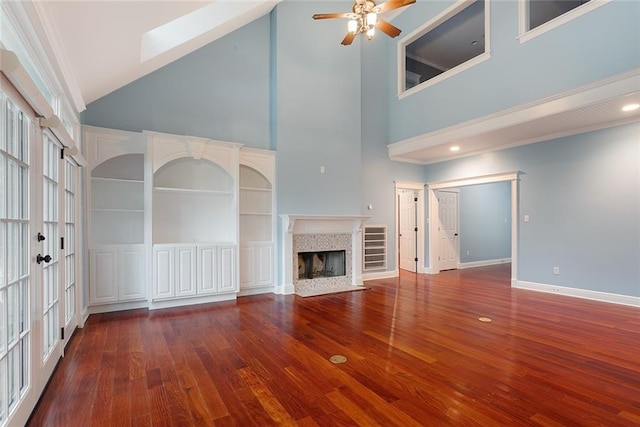 700 Dewey Ave, Slidell, LA 70458 - unfurnished living room featuring high vaulted ceiling, ceiling fan, wood finished floors, a tiled fireplace, and baseboards
