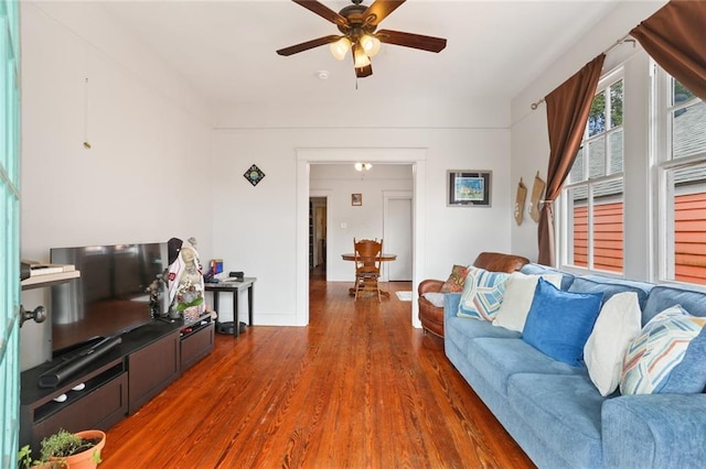 living room featuring ceiling fan and dark hardwood / wood-style floors