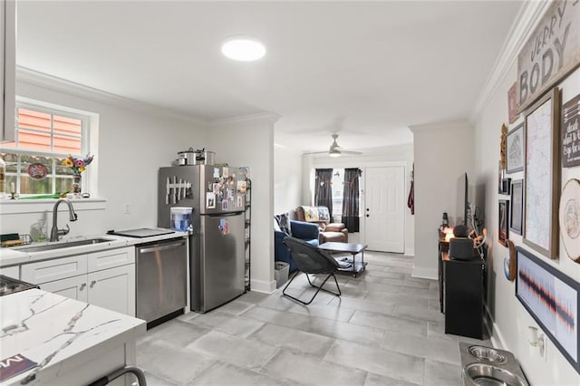 kitchen with white cabinetry, stainless steel appliances, sink, ornamental molding, and light stone counters