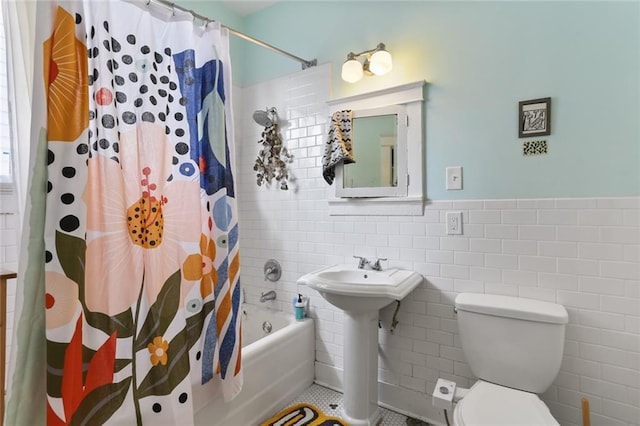 bathroom with toilet, shower / tub combo with curtain, tile patterned floors, and tile walls