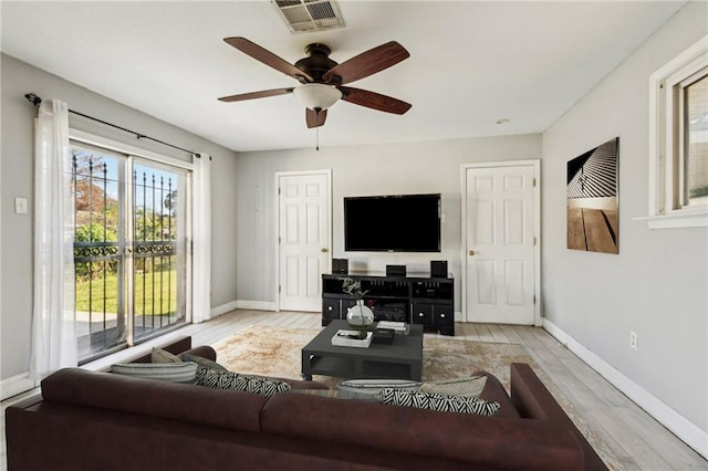 living room featuring light hardwood / wood-style flooring and ceiling fan