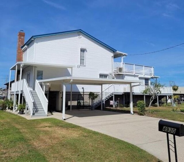 rear view of house with a yard and a carport