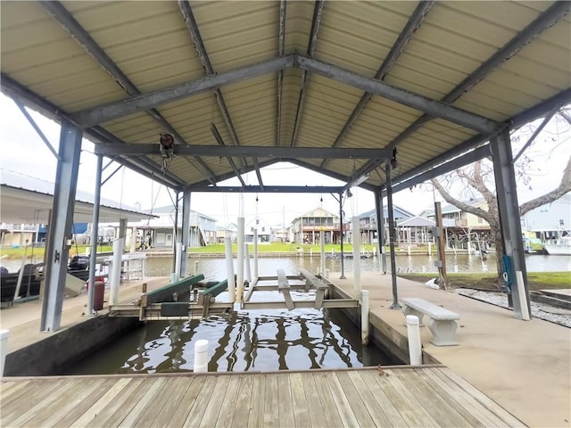 view of dock with a water view, boat lift, and a residential view