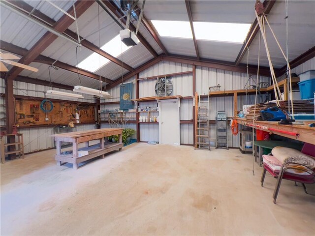 garage with metal wall, a workshop area, and a garage door opener