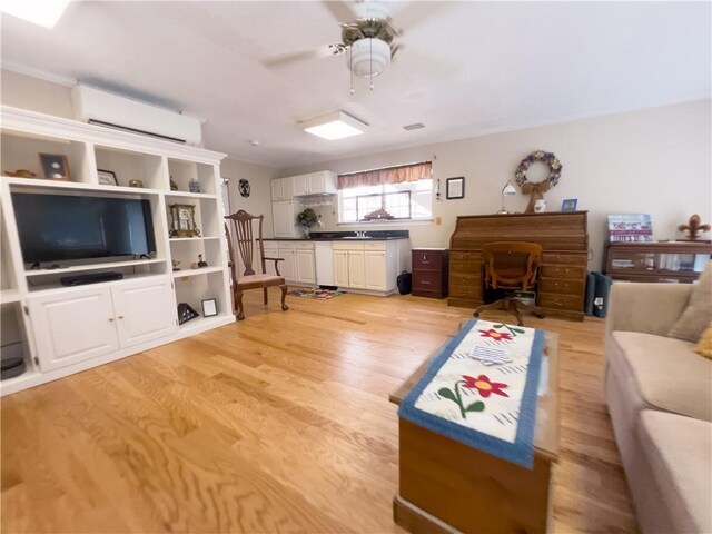 kitchen with sink, light hardwood / wood-style flooring, white cabinetry, and ornamental molding