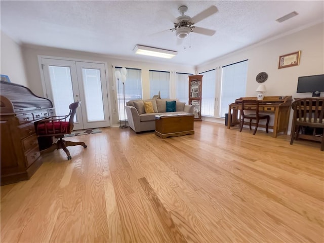 living room with visible vents, a ceiling fan, a textured ceiling, french doors, and light wood-style floors