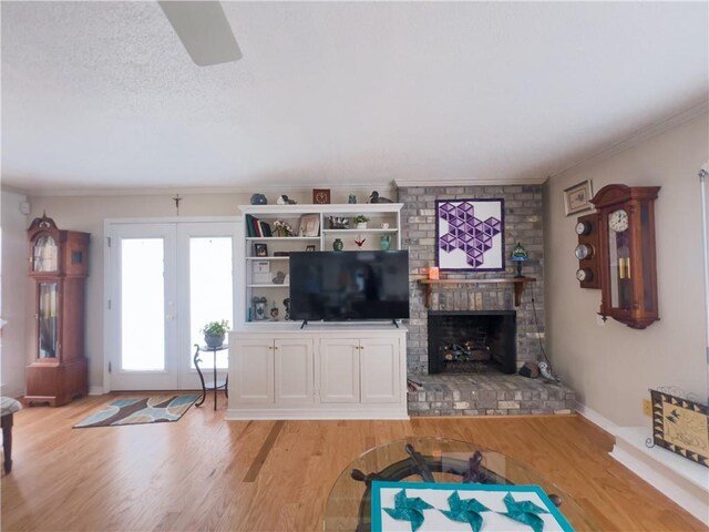 living room featuring a fireplace, light hardwood / wood-style floors, and ceiling fan