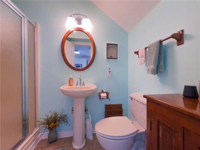 bathroom with vaulted ceiling, a stall shower, tile patterned flooring, and toilet