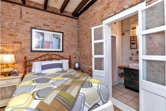 bedroom with light tile patterned flooring, beamed ceiling, and brick wall