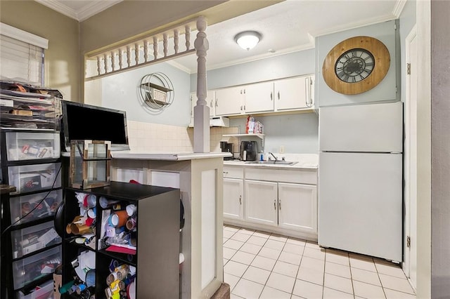 kitchen featuring white cabinetry, light tile patterned floors, white refrigerator, and crown molding