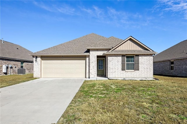 view of front of property featuring cooling unit, a garage, and a front lawn