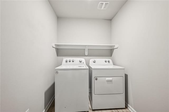 clothes washing area with washing machine and dryer