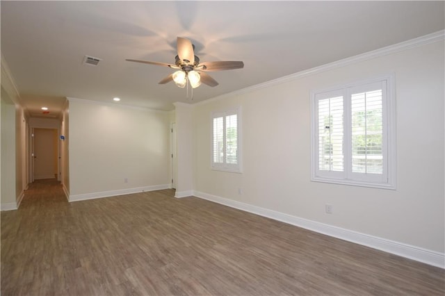 spare room with crown molding, ceiling fan, and dark wood-type flooring