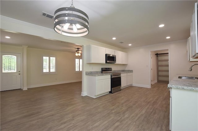 kitchen with stainless steel appliances, white cabinetry, sink, and crown molding