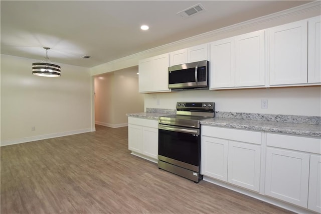 kitchen with stainless steel appliances, white cabinetry, light wood-type flooring, and decorative light fixtures