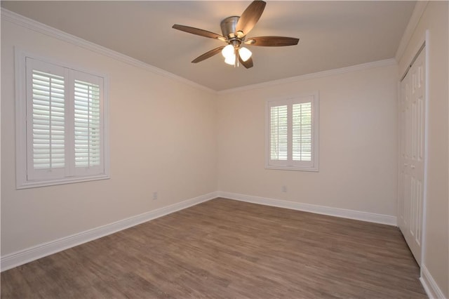 empty room with ceiling fan, ornamental molding, dark hardwood / wood-style floors, and a healthy amount of sunlight