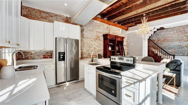 kitchen featuring brick wall, appliances with stainless steel finishes, sink, and white cabinets