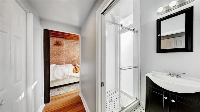 bathroom with vanity, a shower with shower door, and hardwood / wood-style floors