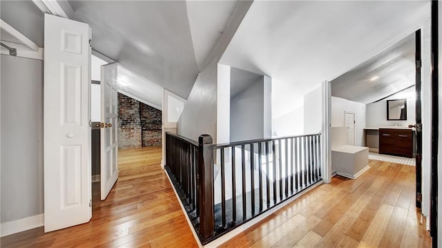 hallway featuring lofted ceiling and light wood-type flooring