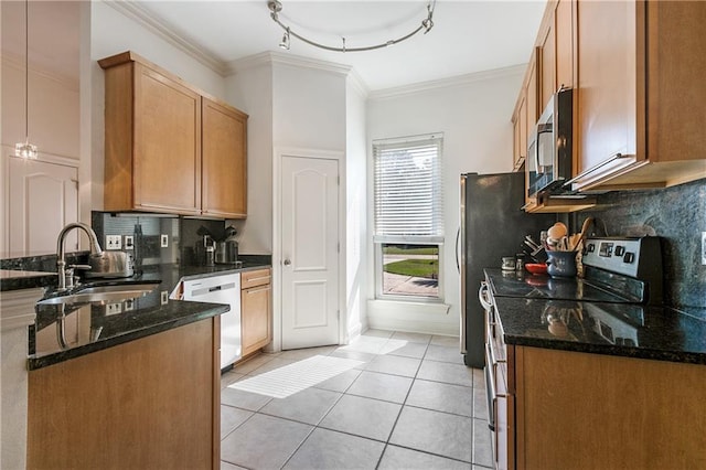 kitchen with backsplash, stainless steel appliances, sink, and dark stone counters