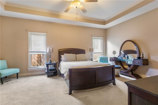 bedroom featuring light carpet, a tray ceiling, crown molding, and ceiling fan