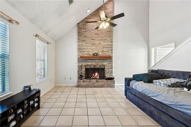 tiled living room with ceiling fan, lofted ceiling, a brick fireplace, and a textured ceiling