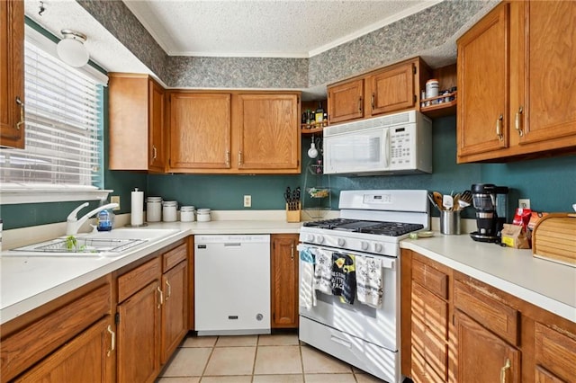 kitchen with white appliances, sink, a textured ceiling, and light tile patterned floors