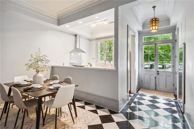 dining room featuring a notable chandelier, a tray ceiling, and ornamental molding