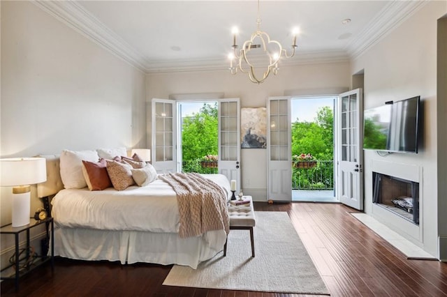 bedroom with multiple windows, dark hardwood / wood-style floors, access to exterior, and a chandelier