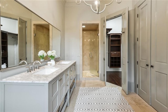 bathroom with an inviting chandelier, tile patterned floors, vanity, and a shower with door