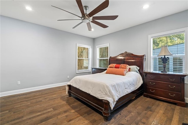 bedroom featuring dark wood-type flooring, ceiling fan, and multiple windows