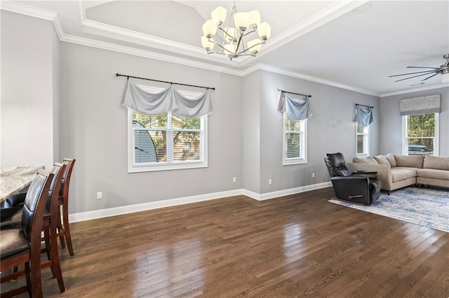 dining area featuring a tray ceiling, ceiling fan with notable chandelier, ornamental molding, and dark hardwood / wood-style floors