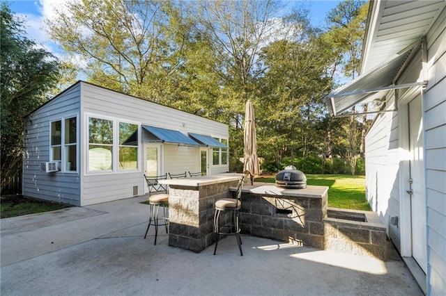 view of patio featuring cooling unit, an outdoor bar, and area for grilling