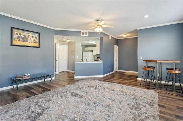 living room featuring dark wood-type flooring, ceiling fan, and ornamental molding