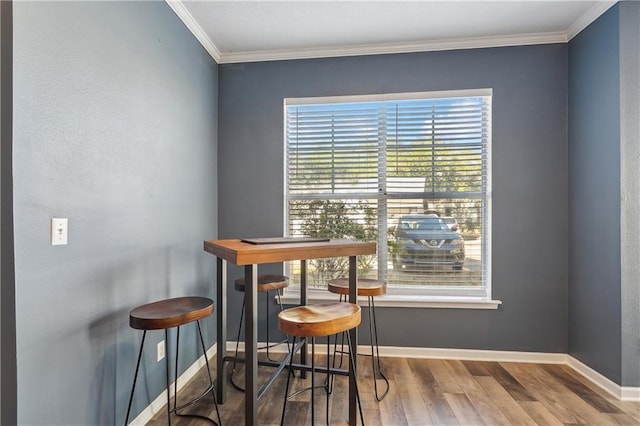 dining space featuring crown molding and wood-type flooring