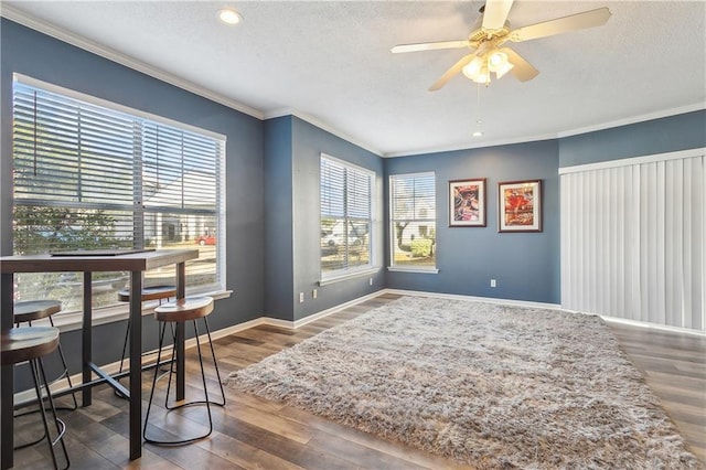 home office featuring wood-type flooring, a healthy amount of sunlight, ceiling fan, and ornamental molding