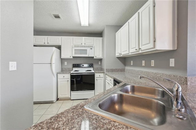 kitchen with white appliances, light tile patterned floors, sink, and white cabinets