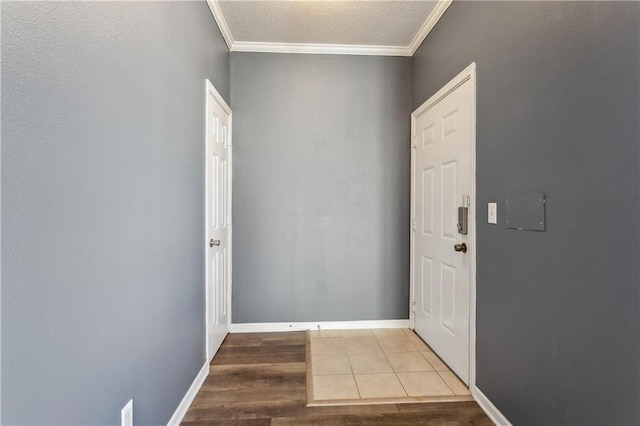 entryway featuring tile patterned flooring, ornamental molding, and a textured ceiling